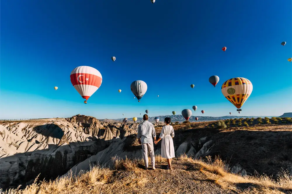couple watching the hot Air balloon in the love Valley in Cappadocia